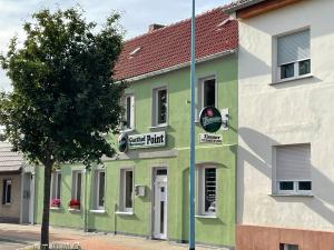 a green and white building with a sign on it at Gasthof und Pension Bernburger Point in Bernburg