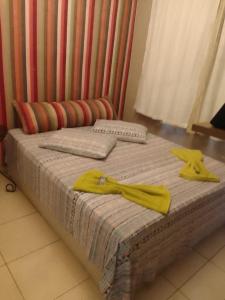 a bed with two yellow towels on top of it at Apto no térreo com 2 quartos in Belo Horizonte