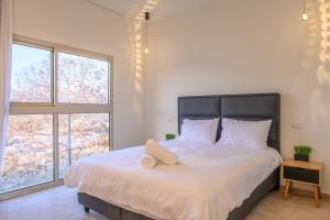 a bedroom with a large bed with a pillow on it at Villa Lausanne - View in Dāliyat el Karmil
