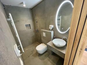 a bathroom with a toilet and a sink and a mirror at Villa T & V in Privlaka +28 photos