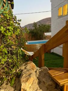 a backyard with a wooden bench and a swimming pool at נוף במגדל in Migdal