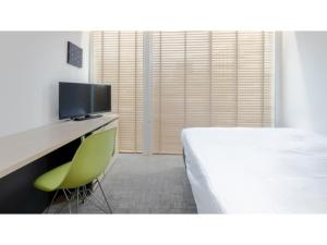 a bedroom with a bed and a desk with a television at The OneFive Sendai - Vacation STAY 44966v in Sendai +20 photos