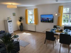 Una sala de estar con una mesa y un televisor en la pared. en to the lakeside promenade, en Überlingen 7 fotos más