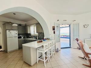 a kitchen with an archway over a white counter top at Beachfront-Santa Marina Vacation Home in Parikia