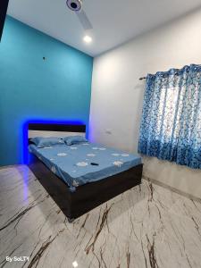 a bedroom with a bed in a blue room at Yogratna Classic in Pune