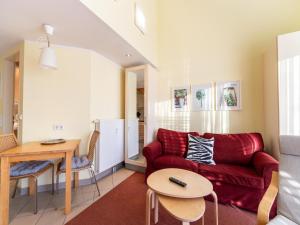 a living room with a red couch and a table at Ideale Familienwohnung in der Natur in Granzow +22 photos
