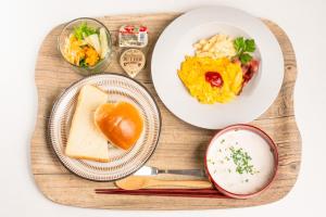 尾道市にあるHOTEL PG -2- - Vacation STAY 38330vの食べ物の皿が置かれた木製のテーブル