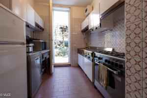 Una cocina con electrodomésticos de acero inoxidable y una gran ventana. en Villa Lucy - Porzione di villa con giardino, en Varenna