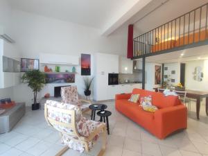 a living room with an orange couch and chairs at Casa del Poggio Barone - Limone in Rodi