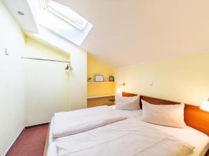 a bedroom with two beds and a skylight at Unvergessliches Apartment am See in Granzow