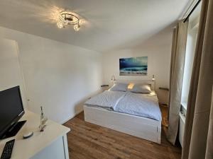 a bedroom with a bed and a desk with a computer at Raphael - "Frank Sinatra" in Timmendorfer Strand