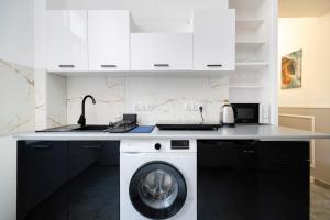 una cocina con lavadora bajo una barra en Centrum 2 Łódź 7 Próchnika21, en Łódź