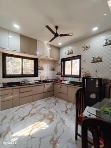 a kitchen with a marble floor and a ceiling fan at Yogratna Classic in Pune