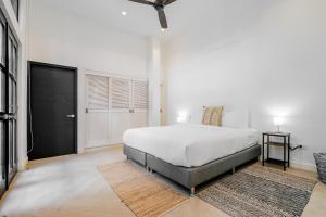 a bedroom with a white bed and a black door at Casa Lefevre by Wynwood House in Panama City