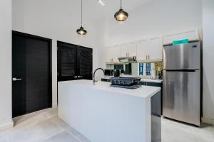 a kitchen with a white counter and a refrigerator at Casa Lefevre by Wynwood House in Panama City