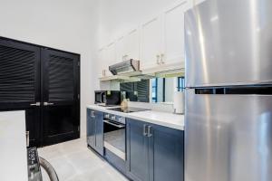 a kitchen with blue cabinets and a stainless steel refrigerator at Casa Lefevre by Wynwood House in Panama City +102 photos