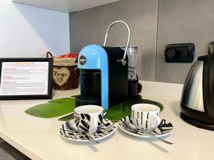 Una cafetera y dos tazas en un mostrador en Lecco City Center Apartment, en Lecco