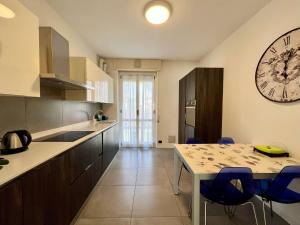 Una cocina con una mesa y un reloj en la pared. en Lecco City Center Apartment, en Lecco