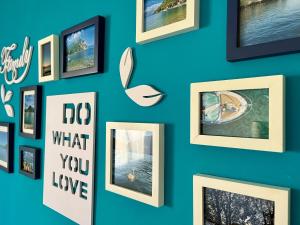 una pared con cuadros enmarcados en una pared azul en Lecco City Center Apartment, en Lecco 7 fotos más