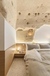 1 dormitorio con cama y pared de piedra en La Dimora Di Metello, en Matera