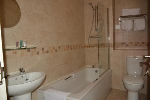 a bathroom with a toilet and a tub and a sink at The Rose & Crown York in York