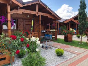 a house with a chair and flowers in front of it at Domki letniskowe KEYA in Gąski