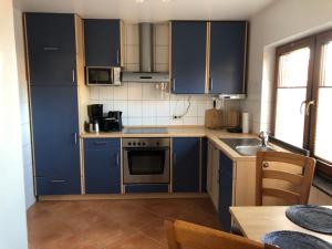 a kitchen with blue cabinets and a sink at Meldorf-Ferienhaus in Meldorf