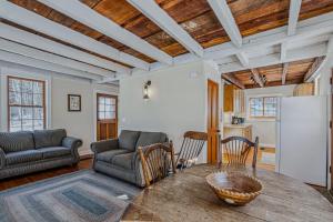 a living room with a table and a refrigerator at Historic Charm Located On the River - Rustic Chic in Woodstock