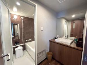 a bathroom with a sink and a tub and a toilet at Second Inn Hana Hotel Hanazono Inter - Vacation STAY 40341v in Fukaya +10 photos