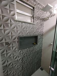 a bathroom with a tiled wall with a window at Apto com Garagem - PENHA in Rio de Janeiro +19 photos