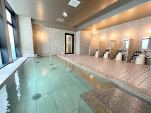 a large bathroom with a pool of water with toilets at Second Inn Hana Hotel Hanazono Inter - Vacation STAY 40274v in Fukaya