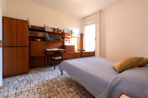 un dormitorio con una cama y un escritorio en Villa Lucy - Porzione di villa con giardino, en Varenna