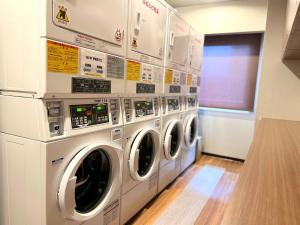 a laundry room with three washing machines and a window at Second Inn Hana Hotel Hanazono Inter - Vacation STAY 40320v in Fukaya