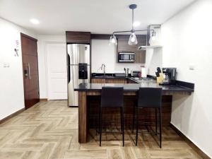 a kitchen with a counter and stools in it at Elegante Loft Pitagoras 1 in San Lorenzo +10 photos