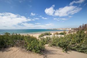 una playa de arena con vistas al océano en GGHH House Hotel, en Marina di Modica