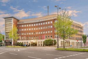 a large brick building with a street in front of it at Hotel Unique Majestic in Dortmund