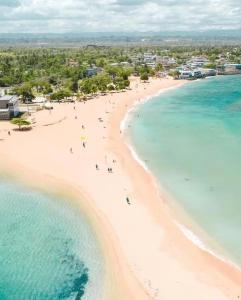 an aerial view of a beach with people in the water at Tiny wooden home in Vega Baja