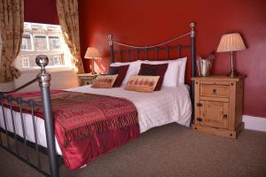 una camera con un letto con una parete rossa di The Rose & Crown York a York