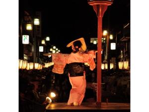 Una mujer está parada en una calle por la noche. en Hotel Tetora Resort Tateyama Kokusai - Vacation STAY 45318v, en Tateyama 3 fotos más