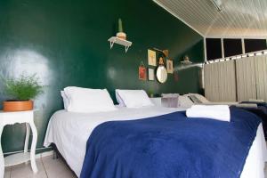 a bedroom with a large bed and a green wall at Happiness House Hospedagem in Cuiabá