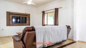 a living room with a couch and a tv at Casa ampla com lazer completo na Regiao dos Lagos in São Pedro da Aldeia
