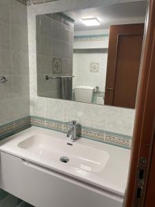 a bathroom with a white sink and a mirror at Finestra sul golfo in Balestrate