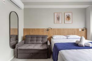 a bedroom with two beds and a chair at Apartamento completo localizado em um dos melhores bairros de Porto Alegre. in Auxiliadora +15 photos