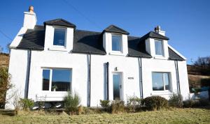 a white house with a black roof at Stratheyre Cottage in Portree