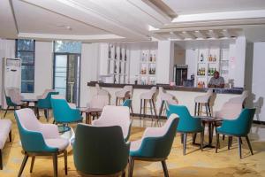 a room with chairs and tables and a bar at Wils Hotel Supreme in Lusaka