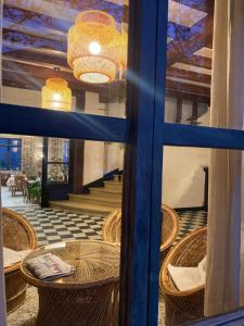 a view of a room with tables and chairs through a window at Les Platanes in Raucoules
