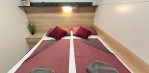 a bed with red pillows in a room at Mobilhome Maja in Pirovac +31 photos
