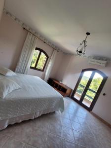 une chambre avec un lit et deux fenêtres dans l'établissement Casa de Campo ampla e confortavel em Araçoiaba da Serra com lareira, perfeita para o friozinho, à Araçoiaba da Serra 39 autres photos