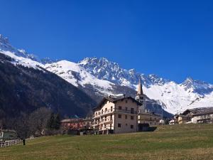 un edificio in un campo con le montagne sullo sfondo di Maisonnette de montagne a Ollomont