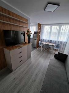 salon z dużym telewizorem i stołem w obiekcie Apartament Gwiezdna 15 w mieście Legnica +13 zdjęć